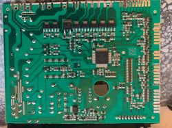 Płyta główna zmywarki pokazująca elementy elektroniczne i ścieżki na zielonym laminacie.