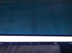 Dolna część ekranu LCD z jasnym pasem i widocznymi przebarwieniami