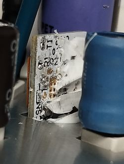 Close-up of PCB showing UART pads T1 and R1 with white service adhesive