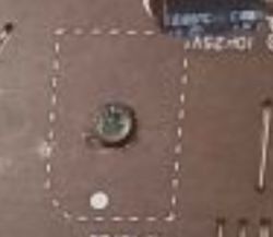 Fragment płytki PCB z zaznaczonym obszarem i małym elementem SMD w środku