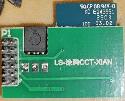 Close-up of a green PCB with electronic components and printed codes