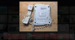 Back of a Slican landline phone with handset and coiled cord on a wooden surface