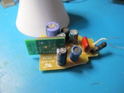 Electronic circuit with capacitors and other components on a blue surface.