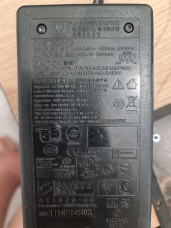 Close-up of an HP power adapter with model and technical specifications.