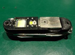 Zbliżenie zmodyfikowanego scyzoryka z widoczną płytką PCB i diodami LED na zielonym tle
