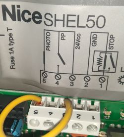 Zbliżenie na schemat połączeń napędu Nice SHEL50 z kablami.