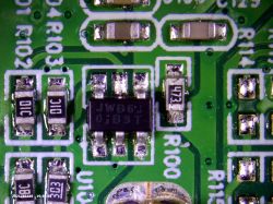 Mikroskopowe zbliżenie płytki drukowanej z elementami elektronicznymi.