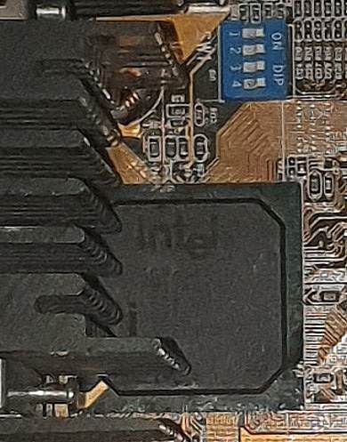Zbliżenie na płytę główną z mostkiem Intel i przełącznikami DIP.