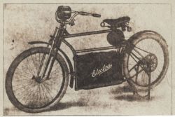 Czarno-białe zdjęcie starego motocykla elektrycznego Electra z 1911 roku, z widocznym silnikiem i pokrowcem na ramie.