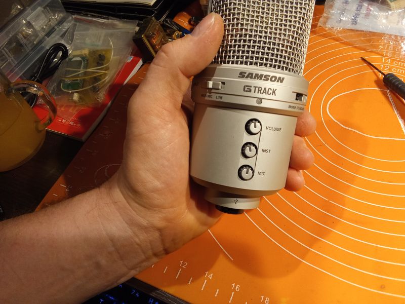 Ręka trzyma mikrofon pojemnościowy Samson G Track.