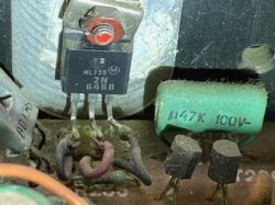 Zbliżenie na zabrudzony tranzystor 2N6488 Motorola i kondensator 4,7 µF 100 V