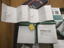 User manual and boxes of smart switches on a table.