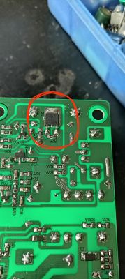 Płytka PCB z elementem SMD w czerwonym okręgu; widoczne ścieżki i pola lutownicze.