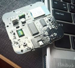 Circuit board with visible components placed on a laptop keyboard
