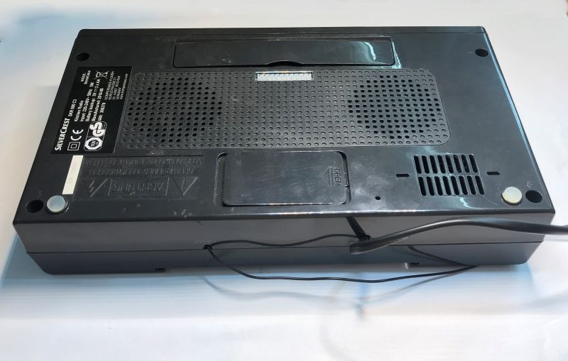 Bottom of a black SilverCrest radio with speaker grille, battery flap, and specification label