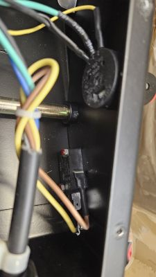 Wnętrze urządzenia elektrycznego z kolorowymi przewodami i potencjometrem.