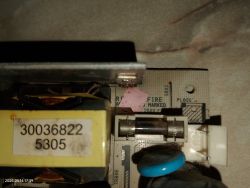 Zbliżenie na uszkodzony bezpiecznik na płytce drukowanej z elementami elektronicznymi zasilacza.