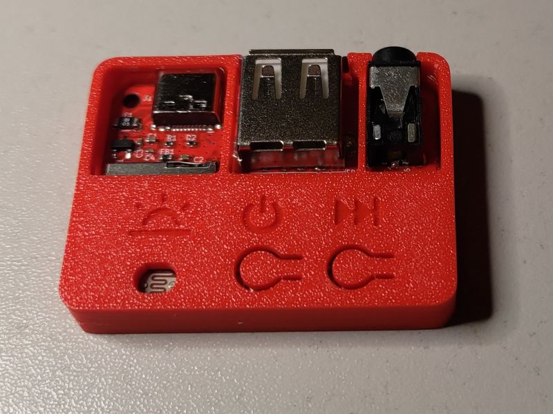 Small music player in red casing with USB, mini-jack connectors and light sensor