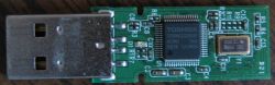 Zbliżenie płytki PCB pendrive’a z wtykiem USB i układem Toshiba na zielonym laminacie