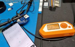 Mobile Phone and Flipper Zero on Electronics Desk Mobile phone and Flipper Zero device on a desk with electronics.