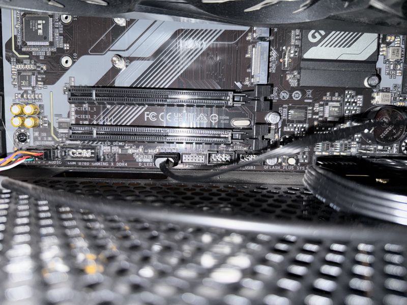 Widok dolnej części płyty głównej Gigabyte B760 z widocznymi złączami LED i USB
