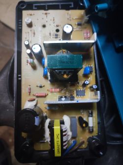 Wnętrze ładowarki Makita DC1414T z widoczną płytką PCB i elementami elektronicznymi