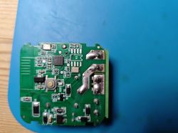 Close-up of a green printed circuit board with electronic components and solder joints.