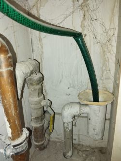 Przewody hydrauliczne i węże w kącie pomieszczenia.