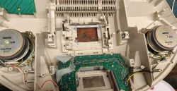 Inside an audio device with two speakers and a green PCB mounted in a plastic housing