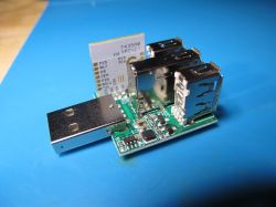 Circuit board with three USB ports and a wireless module, side view.
