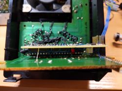 Zbliżenie na wnętrze urządzenia elektronicznego z widocznymi płytkami drukowanymi i przewodami.