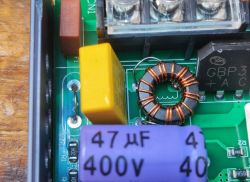Close-up of a PCB with a common mode choke, GBP bridge rectifier and 47µF capacitors