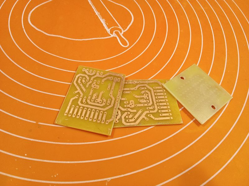 Three printed circuit boards on an orange mat with white circles.