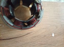 Wnętrze uszkodzonego silnika wkrętarki, z widocznymi śladami przepaleń i stopień plastiku.