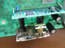 Zbliżenie modułu elektroniki z płytkami PCB, kondensatorami i transformatorem przetwornicy