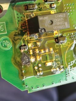 Close-up of a PCB with an Omron relay, solder joints, and visible flux residue