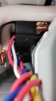 Close-up of the inside of an electrical device showing colored wires and copper busbars.