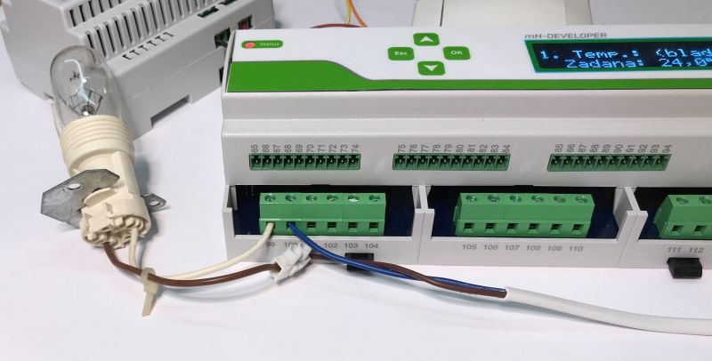 Automation controller with connected wires and a bulb in a socket.