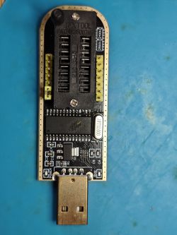 CH341A USB programmer with ZIF socket and pin headers on blue mat