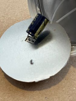 Close-up of a damaged capacitor on a circuit board.