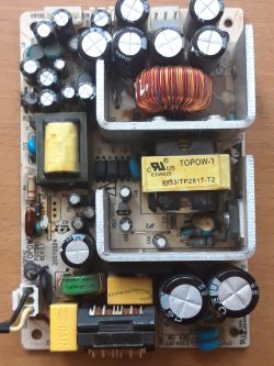 Płytka drukowana z elementami elektronicznymi, trafo i kondensatorami.