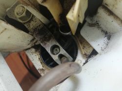 Zbliżenie na wnętrze ekspresu do kawy z widocznymi częściami metalowymi i osadem.