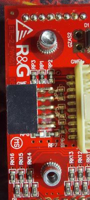 Część czerwonej płytki elektronicznej z oznaczeniami i złączami.