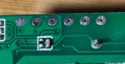 Portion of a circuit board with several round pads and traces.