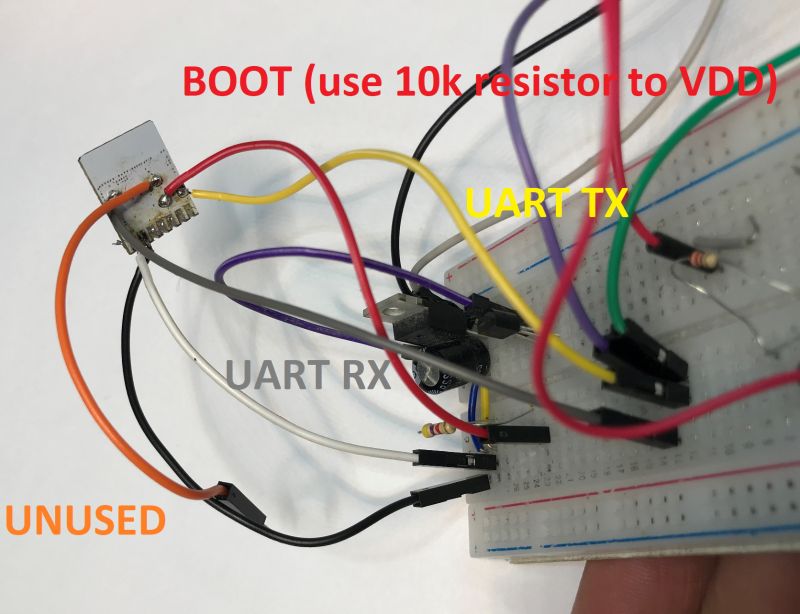 Breadboard with Wires and Port Labels Breadboard with connected wires and labels for BOOT, UART TX, UART RX, and UNUSED ports.