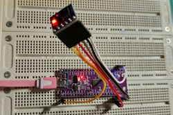 Electronic module on breadboard with connected wires and lit red LEDs
