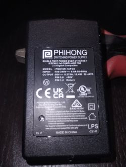 Zbliżenie etykiety zasilacza PoE Phihong, model POE16R-1AFG6, z informacją „2.5 Gigabit Compatible”.