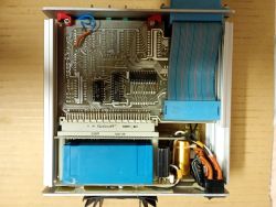 Widok wnętrza urządzenia elektronicznego z płytką PCB i taśmą IDC