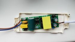Zasilacz z otwartą obudową, ukazujący wnętrze z komponentami elektronicznymi.