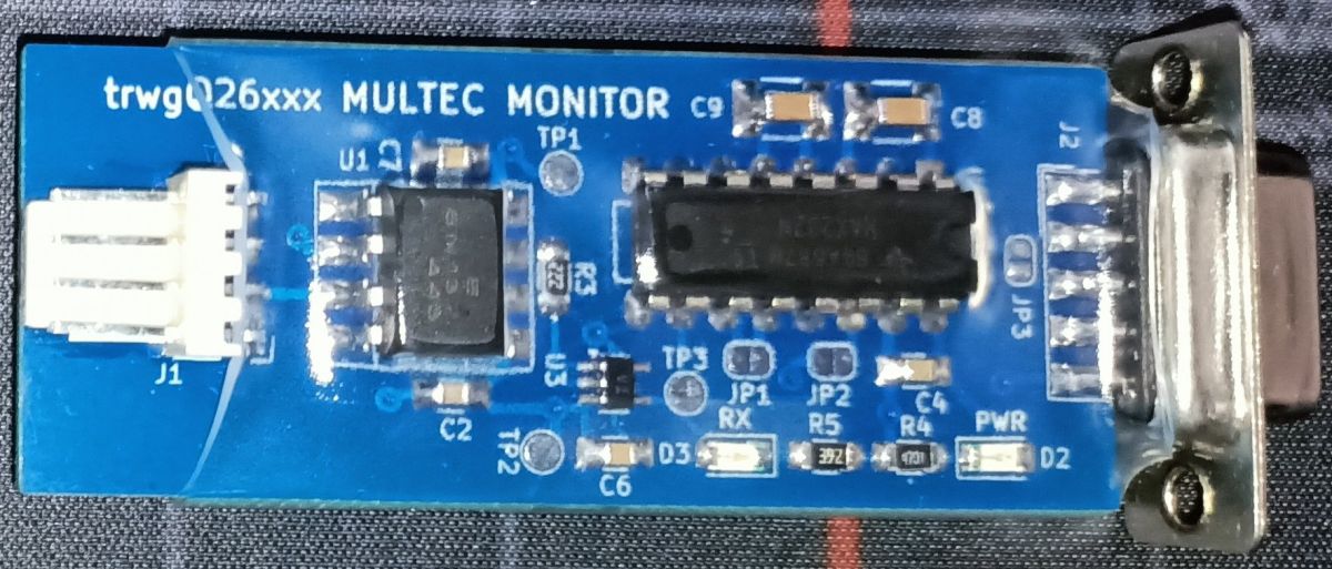 Moduł diagnostyczny MULTEC MONITOR z interfejsem RS232 Płytka urządzenia diagnostycznego z oznaczeniami MULTEC MONITOR i złączem DB9